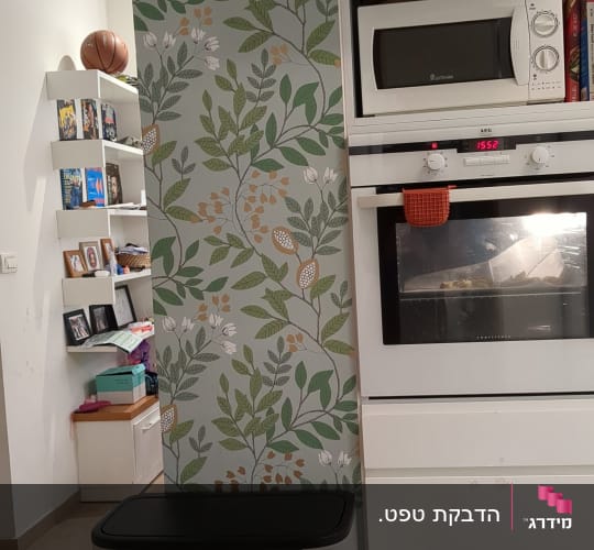 טפט עם עלים ירוקים ופרחים על קיר במטבח